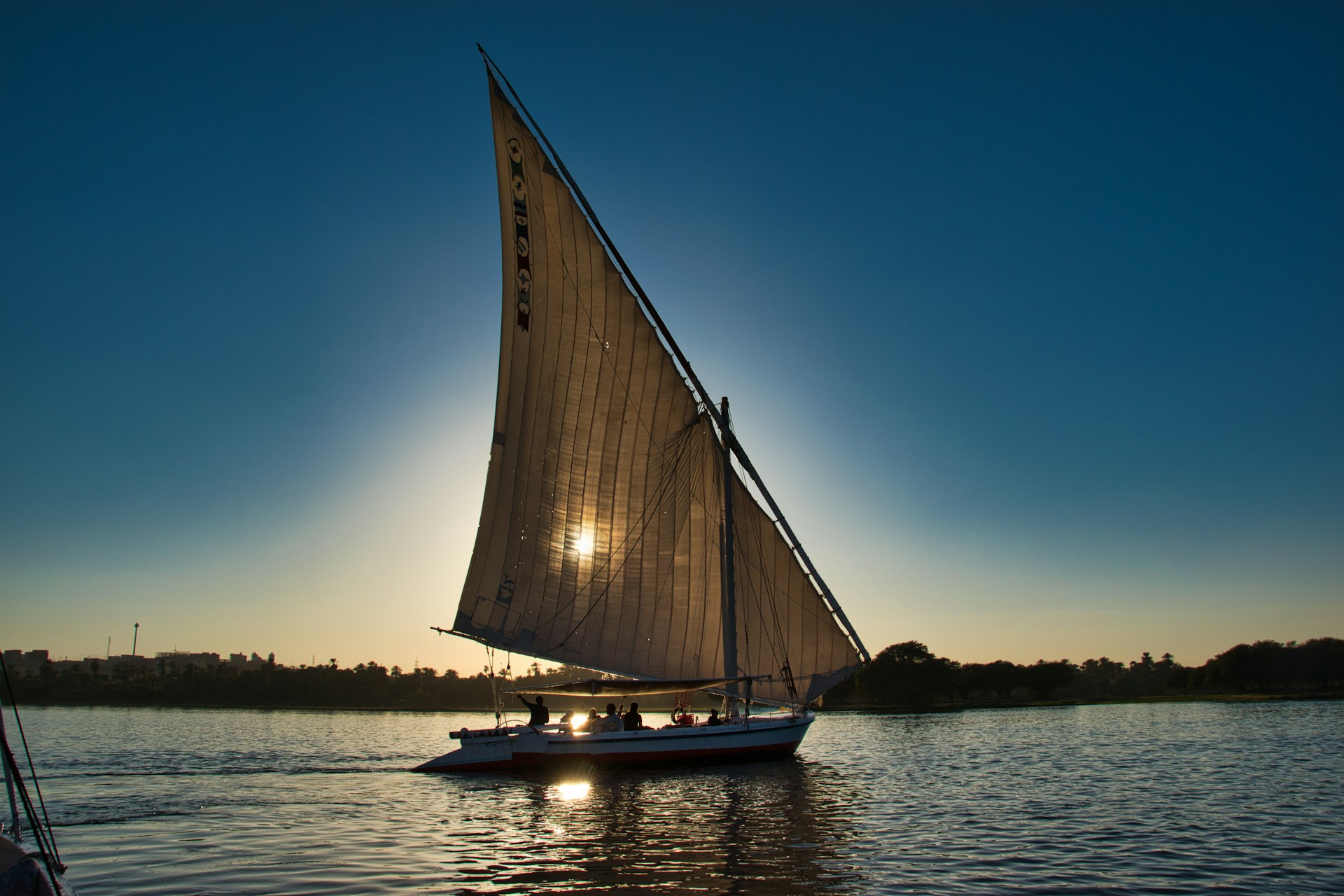 Sailing felucca on the Nile River at sunset